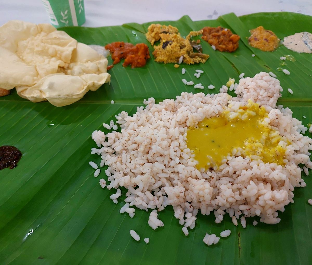 South Indian meal served on a fresh banana leaf – rice with ghee, pickles and appadam