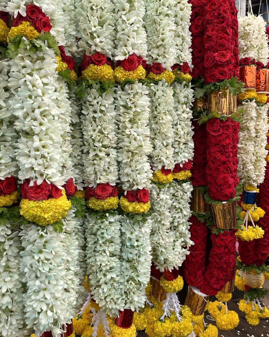 Jasmine, rose and marigold garlands hanging at a flower market in the early morning