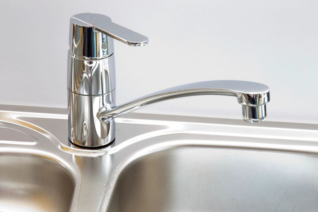 Chrome kitchen mixer tap fitted on a stainless steel sink